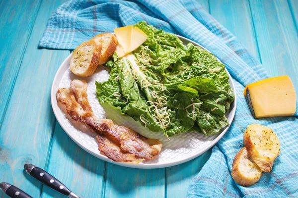 Caesar Salade Met Knapperig Brood Spek Close Blauwe Houten Achtergrond — Stockfoto