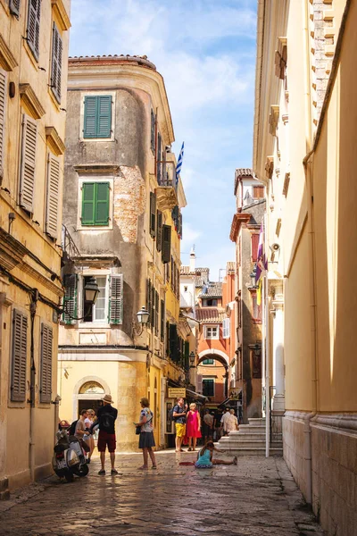 Corfu Adası, Yunanistan - 10.09.2019: Eski Corfu şehri Kerkyra 'nın tipik caddesi. Güneşli bir yaz günü, sarı evler