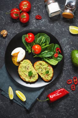 Avokado Meksika soslu avokado soslu sağlıklı tost haşlanmış yumurta, vişneli domates ve siyah taşlı salata. Üst Manzara. Kahvaltı.