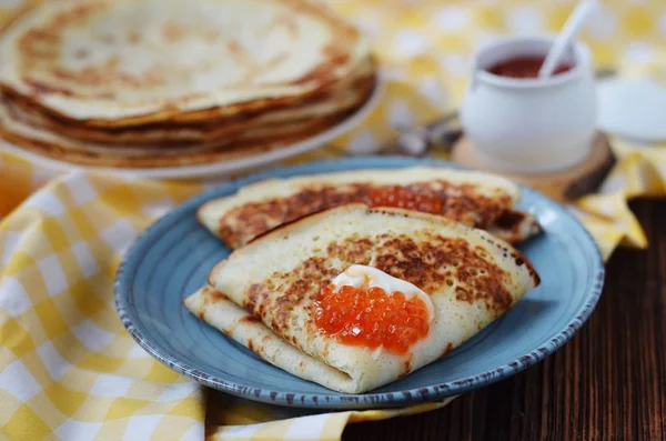 Russische pannenkoeken met zure room en rode kaviaar — Stockfoto