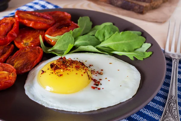 Смажене яйце з ракетним салатом і помідорами — стокове фото