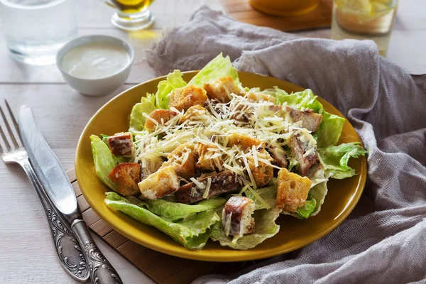 Gemengde Caesar salade met kip op een gele plaat — Stockfoto