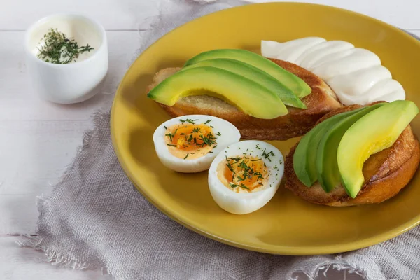 Open broodjes met avocado, eieren en saus — Stockfoto
