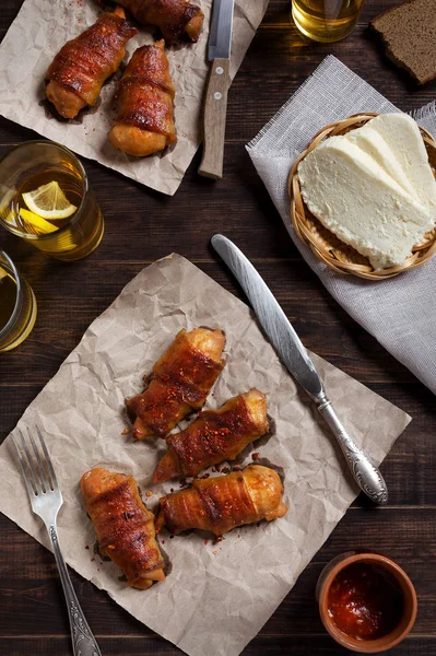 grilled bacon rolls on parchment with cheese