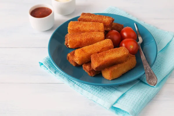 Fried cheese sticks with tomatoes, sauces and a fork
