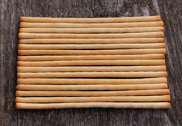 Sabrosos palitos de pan italiano sobre fondo de madera — Foto de Stock