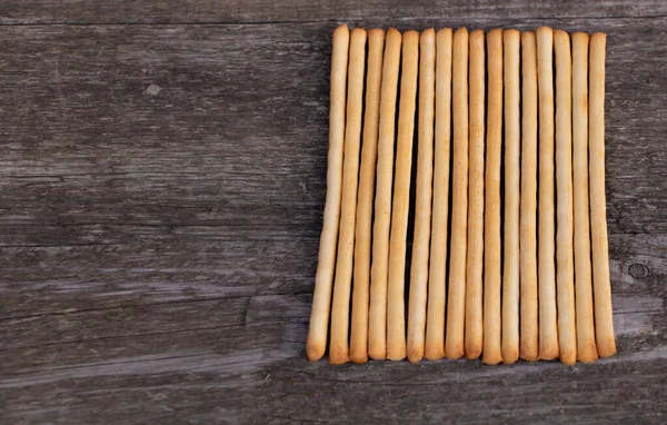 Leckere italienische Brotsticks auf Holzhintergrund mit Kopierraum — Stockfoto