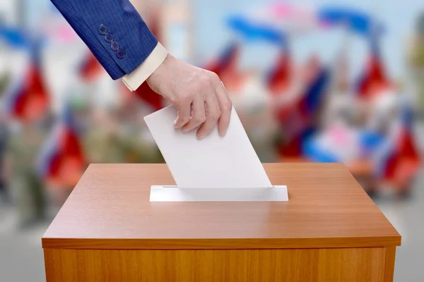 El hombre vota lanzando una papeleta en las urnas — Foto de Stock