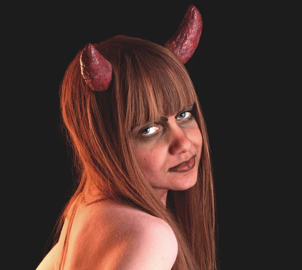 Девушка в облике дьявола на черном фоне — стоковое фото