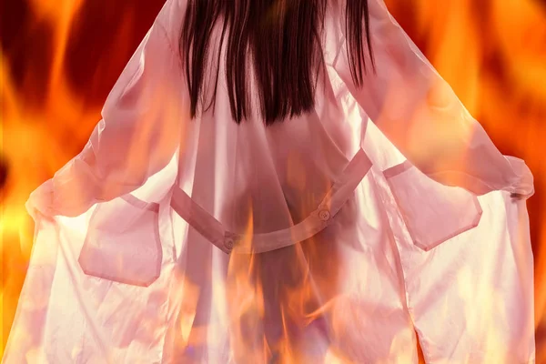 医療用のガウンを着た女の子は火に包まれている. — ストック写真