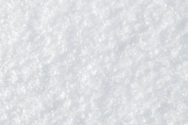 Taze karların arkaplanı beyaz kar taneleriyle kaplıdır.