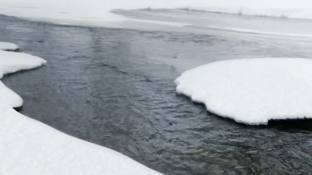 湿雪落在春天湍急流淌的河流上 冬季恶劣天气的概念 — 图库视频影像