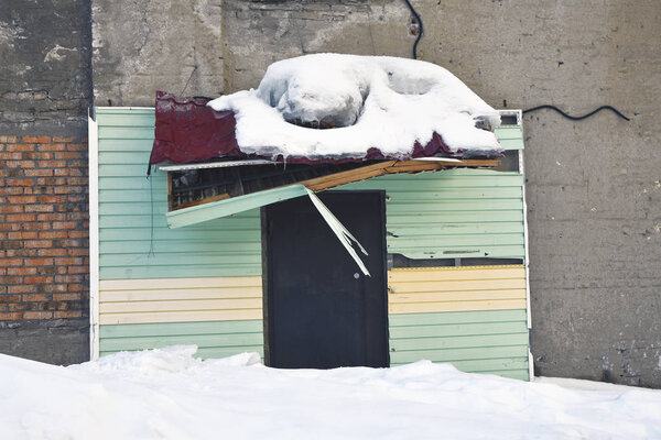 Broken roof of an old building from fallen snow and ice. Winter emergency