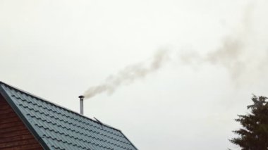 Gri gökyüzündeki bacadan dumanlar bir apartmandan, hamamlardan geliyor. 4K video. Hızlı zaman aralığıyla.