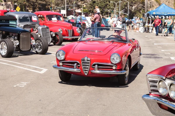 Человек водит классический красный автомобиль Alfa Romeo Milano — стоковое фото