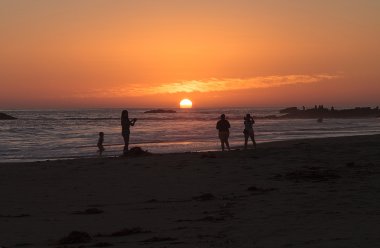 Gün batımında sahilde zevk insan silüeti