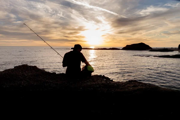 Silhouette de pêcheur au coucher du soleil — Photo