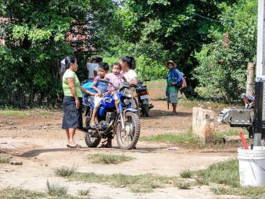 Bir motor bisikleti üzerinde genç çocuklarla aile 