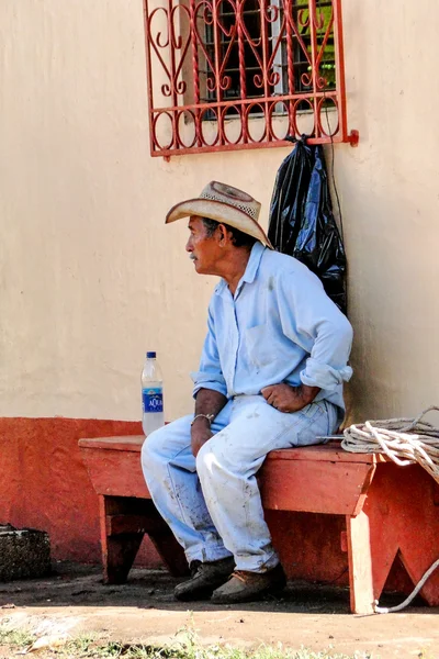 Guatemalteekse cowboy berust op een kerk bankje — Stockfoto