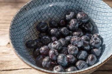 Mavi ve beyaz bir kase içinde organik yaban mersini