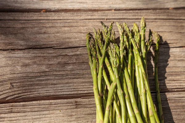 Asparagi freschi e sottili sullo sfondo del legno rustico — Foto Stock