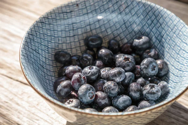 Mavi ve beyaz bir kase içinde organik yaban mersini 
