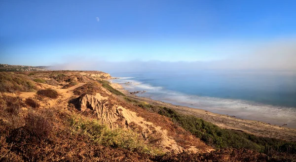Moon in the sky as Fog drifts in over the ocean at Crystal Cove — Stock Photo, Image
