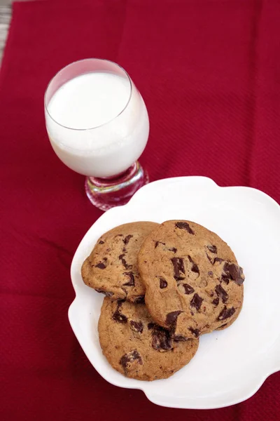 Chocolate chip cookies on a white plate with whole milk — Stock Photo, Image