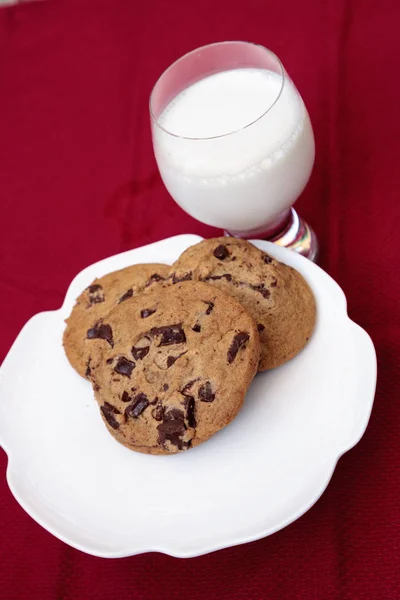 Chocoladeschilferkoekjes op een witte plaat met volle melk — Stockfoto