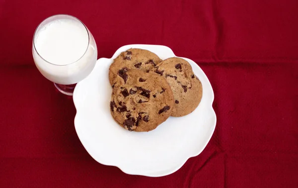 Μπισκότα τσιπ σοκολάτας σε μια λευκή πλάκα με το πλήρες γάλα — Φωτογραφία Αρχείου