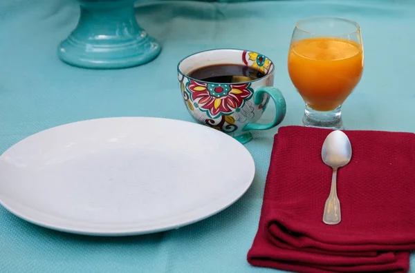 Café negro en una taza de impresión de flores de colores con jugo de naranja — Foto de Stock