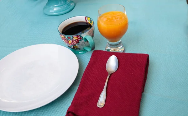 Svart kaffe i en färgsprakande blomma print kopp med apelsinjuice — Stockfoto