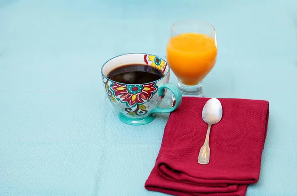 Чорна кава в барвистій чашці з квітковим принтом з апельсиновим соком — стокове фото