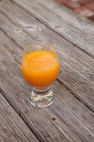 Zumo de naranja recién exprimido en un vaso transparente — Foto de Stock