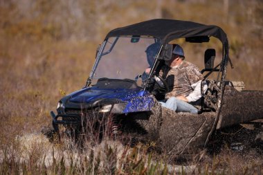 Off-road'a benziyor erkeklerle bir Atv ile bir bataklıkta