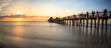 Naples Pier on the beach at sunset clipart