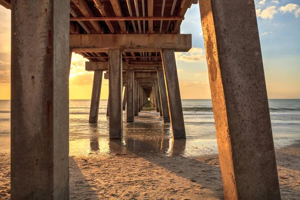 Na praia sob o cais de Nápoles ao pôr-do-sol — Fotografia de Stock