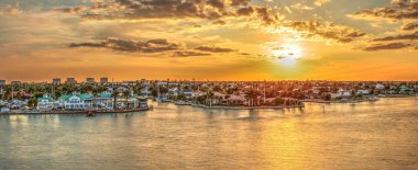 Altın gökyüzü şehir ışıklarının üzerinde Marco Adası, Florida 'daki Fabrika Koyu' nun karşısında.