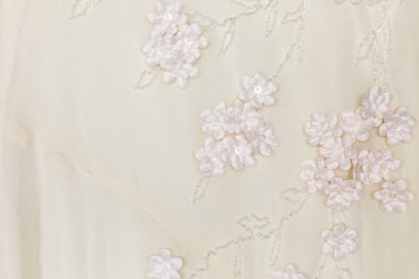 Çiçekli fildişi düğün kumaşı ve boncuklu arkaplan dokusu.