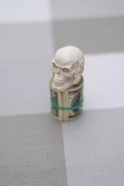 Un cráneo parado en un paquete de dinero, retorcido en un paquete —  Fotos de Stock