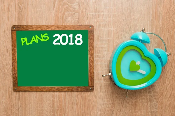 Bespotten, op een houten achtergrond met een klok, plannen 2018 — Stockfoto