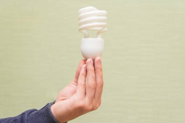 Bir adam elinde tasarruflu ampul