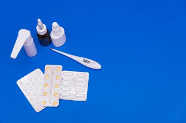 İlaçlar, haplar ve parlak bir arka plan üzerinde bir termometre