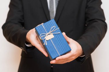 A man holding a gift box in his hands clipart