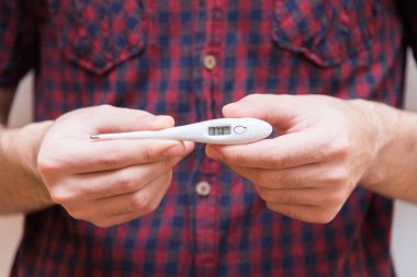 Bir elektrik termometre tutan adam