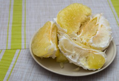 Arıtılmış pomelo bir tabak içinde yalan