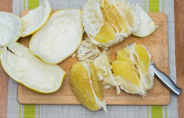 Kız bir pomelo ahşap tahta üzerinde temizler