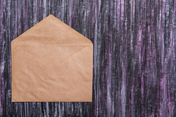 Envelope of Kraft paper. Love letter envelope. Wooden background. Social network.