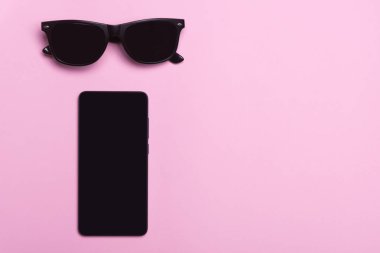 Siyah gözlük. Siyah telefon. Pembe bir arka plan. Siyah telefon ve gözlük bir pembe yalan söylüyorsun.
