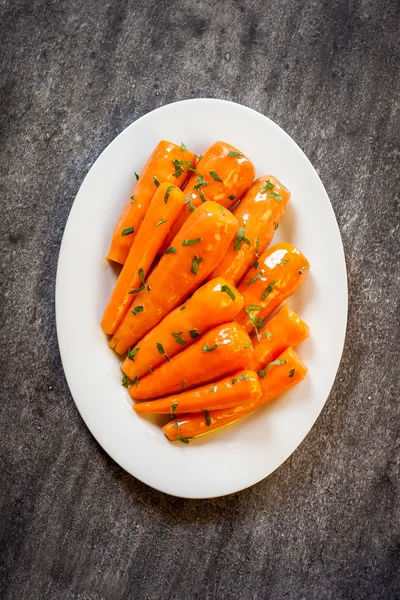 Детская морковка с петрушкой в глазури. Здоровая домашняя жареная морковь, готовая к употреблению — стоковое фото